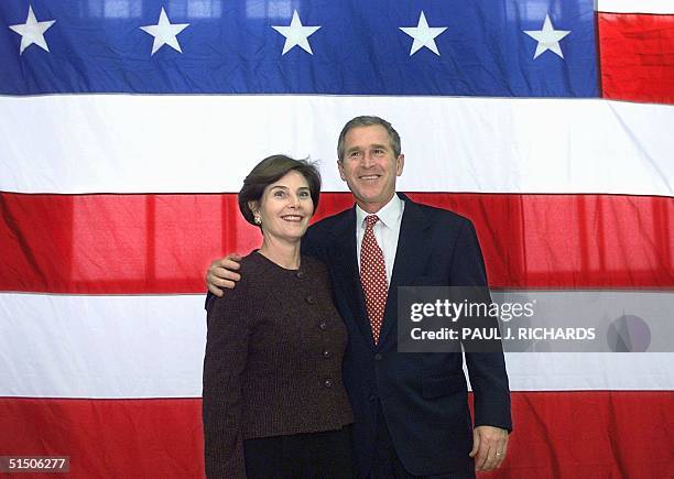 Laura and Texas Governor George W. Bush pose before a US flag as they leave a rally at Presbyterian College in Clinton, South Carolina 18 February...