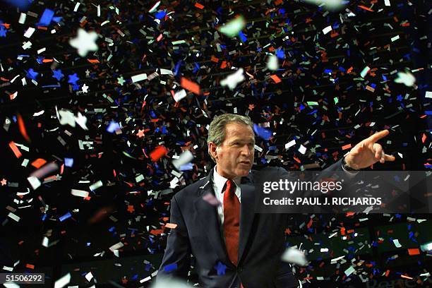 Republican presidential candidate Texas Governor George W. Bush points to someone in the crowd as confettii falls while he attends a homecoming party...