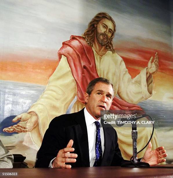 Texas Governor George W. Bush speaks in front of a mural of Jesus Christ while visiting the Teen Challenge of the Midlands in Colfax, Iowa 21 January...