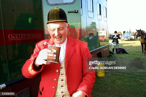 Huntsman takes a nip from a hip flask after returning from a fox hunt in Higham, Suffolk 17 January 2001. Hunt supporters organised a series of...