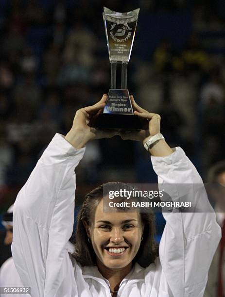 World number one Martina Hingis of Switzerland holds up her trophy after defeating France's Nathalie Tauziat in the final of the Dubai Tennis...