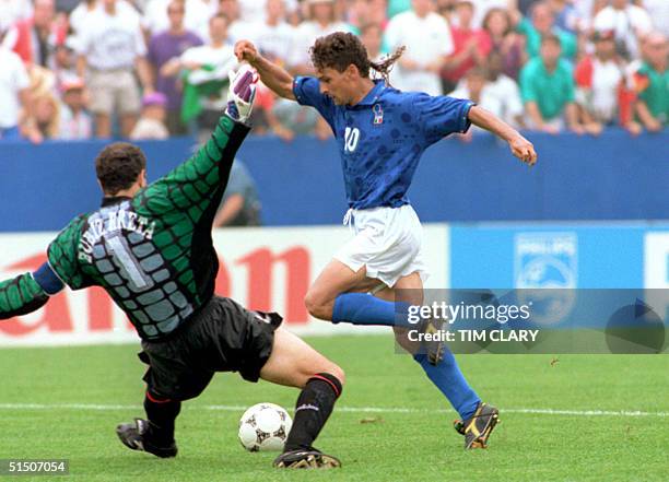 Italian forward Roberto Baggio dribbles past Spanish goalkeeper Andoni Zubizarreta to score his team's first goal 09 July 1994 at Foxboro stadium in...