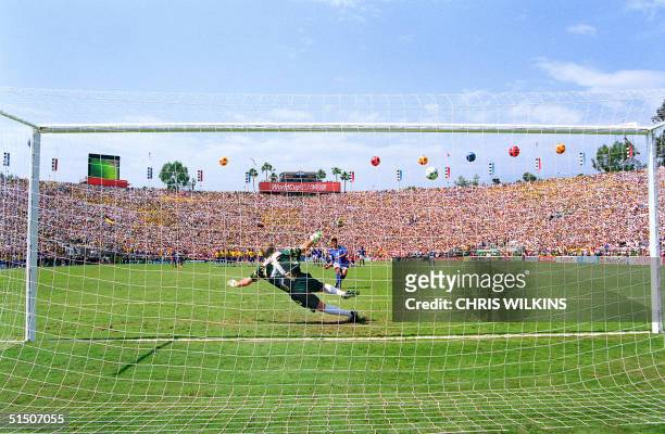 Italian forward Roberto Baggio watches his penalty kick go over the crossbar as Brazilian goalkeeper Claudio Taffarel dives the wrong way during the...