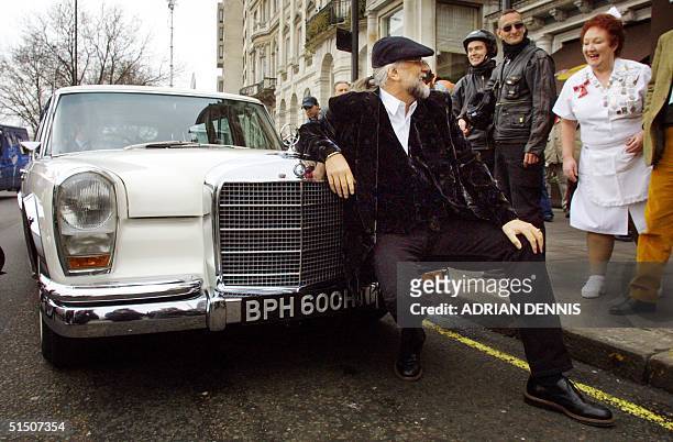 Musician Mick Fleetwood, of Fleetwood Mac fame, sits on the bumper of a Mercedes Benz 600 limousine formerly owned by John Lennon after arriving at...