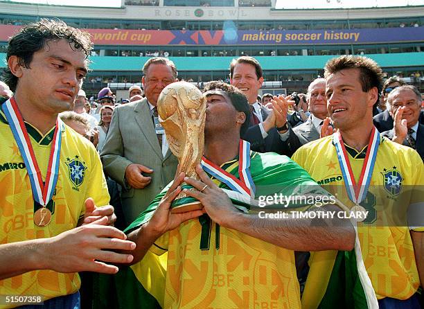 Brazilian forward Romario kisses the FIFA World Cup trophy as his teammates Branco and Dunga look on, after Brazil defeated Italy 3-2 in the...