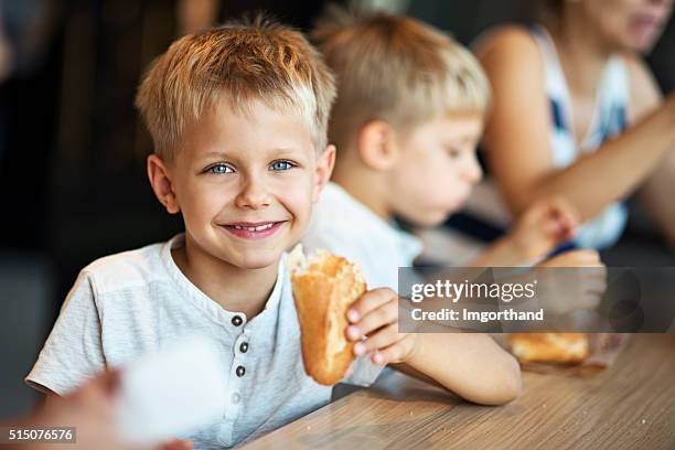 kids eating baugette sandwiches at paris cafe - eating bread stockfoto's en -beelden