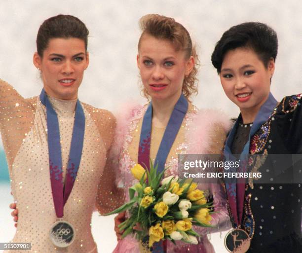 Ukrainian Oksana Baiul , Nancy Kerrigan from the United States and Chinese Chen Lu smile on the podium during the medals' ceremony of the women's...