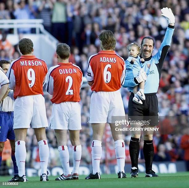 Arsenal and England'i goalkeeper David Seaman salutes the Highbury crowd with his daughter Georgina before his testimonial match versus Barcelona at...