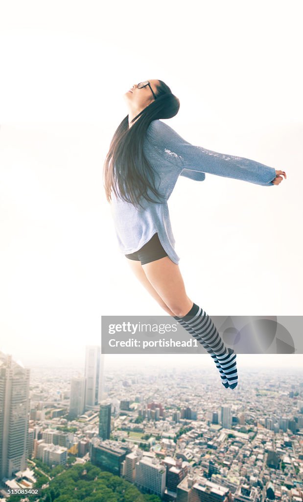 Young woman flying over the cityscape