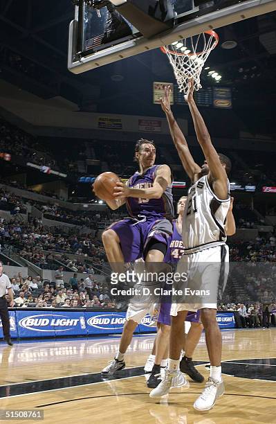 Steve Nash of the Phoenix Suns looks to pass around Tim Duncan of the San Antonio Spurs during the game on October 19, 2004 at the SBC Center in San...