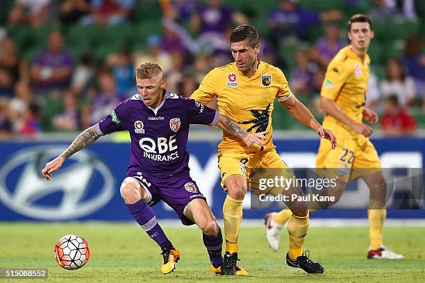 Andy Keogh of the Glory is challenged by Nick Montgomery of the Mariners during the round 23 A-League match between the Perth Glory and the Central...