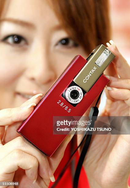 Model displays the world's smallest 4 mega-pixel digital camera "Contax i4R", produced by Japan's electronics giant Kyocera at Asia's largest PC...