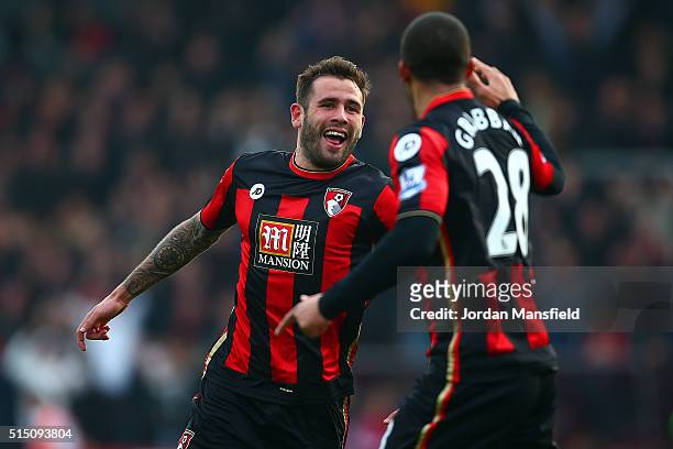 Steve Cook of Bournemouth celebrates scoring his team's third goal with his team mate Lewis Grabban during the Barclays Premier League match between...