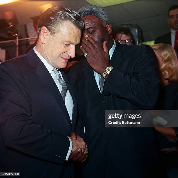 Baseball legend Jackie Robinson is seen conferring with Nelson Rockefeller, Governor of New York, during a press conference at Republican...