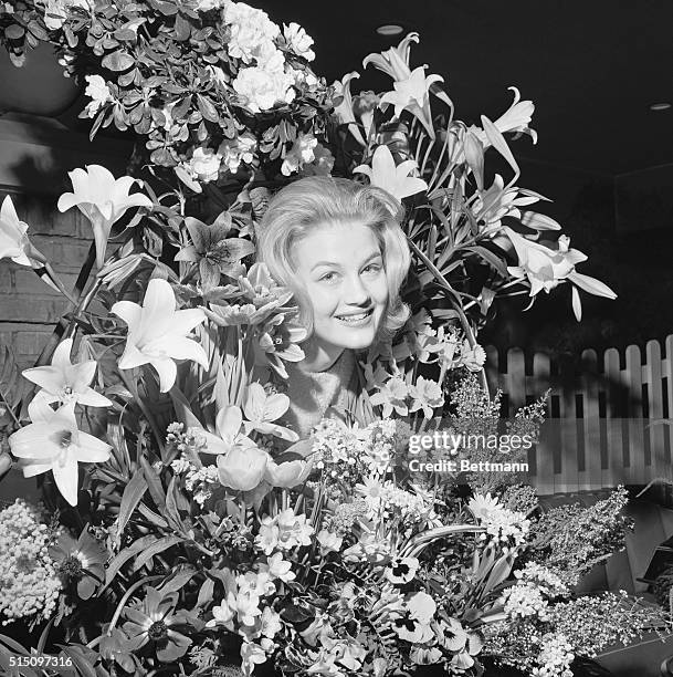 Queen of the Posies. New York: Diane Sawyer of Louisville, Ky., queen of the 47th International Flower Show, poses with some of her subjects as she...