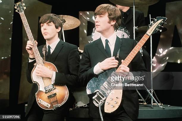 British Rock musicians Paul McCartney and John Lennon , of the group the Beatles, perform on the set of 'The Ed Sullivan Show' at CBS's Studio 50,...