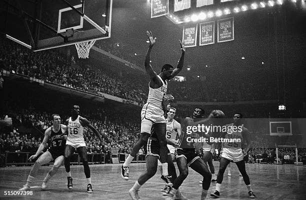 Celtics' Bill Russell makes a formidable appearance as guard against Royals' Oscar Robertson's attempt to score during the second quarter action in...