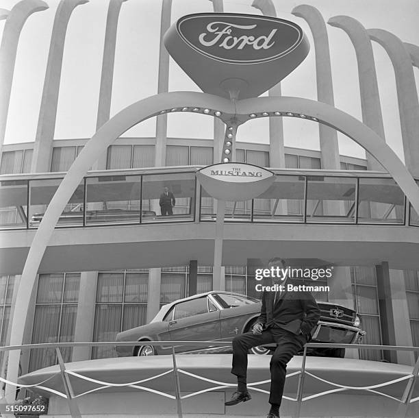 Henry Ford II outside For4d Motor Co. Pavilion at New York World's Fair with unveiled model of Ford Mustang.