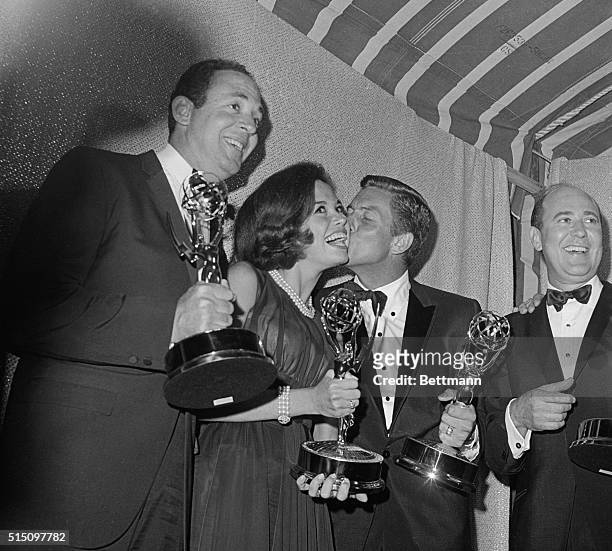 Mary Tyler Moore who plays the television wife of Dick Van Dyke on the Dick Van Dyke Show gets a big kiss from Van Dyke after they won Emmy's as...