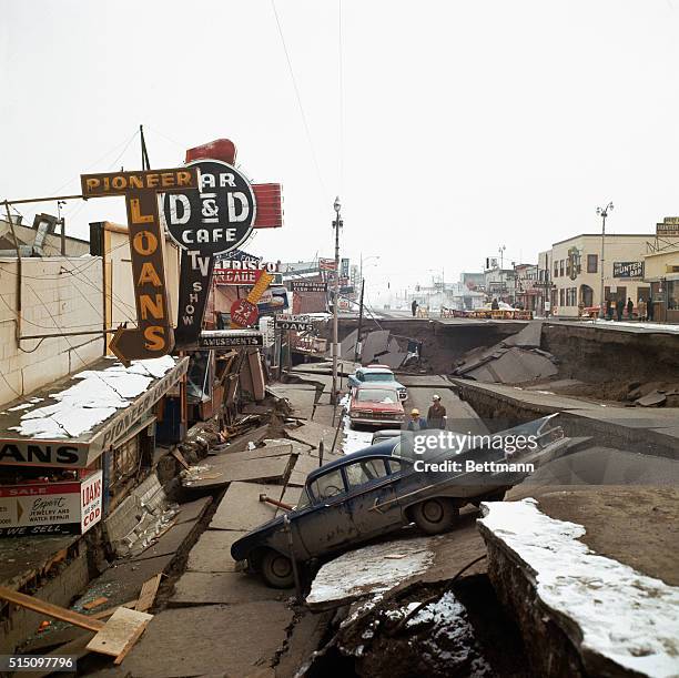 Anchorage, Alaska: The tremendous earthquake that rocked this city late March 27 dropped Fourth Avenue and a row of cars some 20 feet below normal...