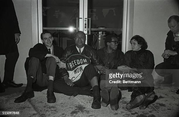 James Farmer, national director of the Congress of Racial Equality, links arms with other demonstrators as they sit in front of the New York City...