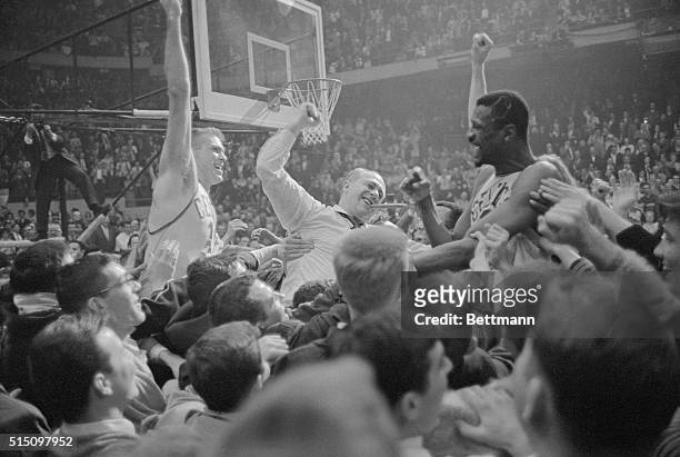 It's a jubilant mob scene as happy fans carry Celtics' Tommy Heinsohn , coach Red Auerbach , and big Bill Russell around the basketball court at...
