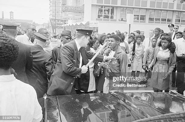 April 27, 1964: Nashville: A Nashville policeman grabs a Negro demonstrator and tells him to move from in front of a patrol wagon. The Negro refused...