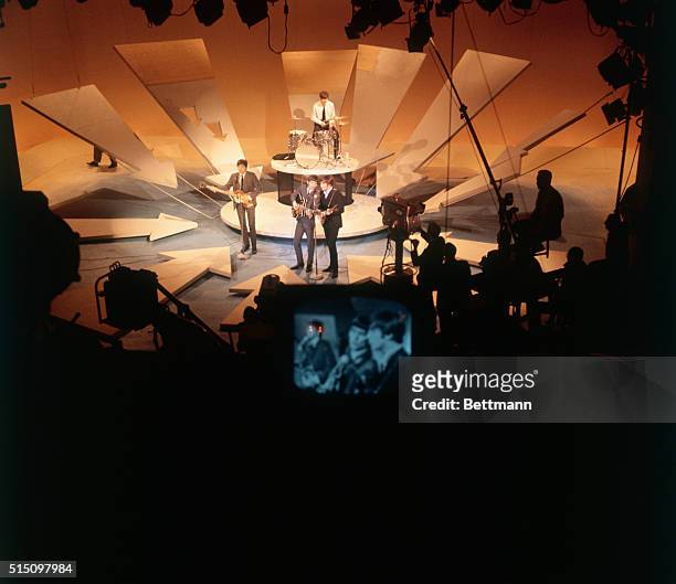 View of the members of British Rock group the Beatles as they perform onstage on 'The Ed Sullivan Show' at CBS's Studio 50, New York, New York,...