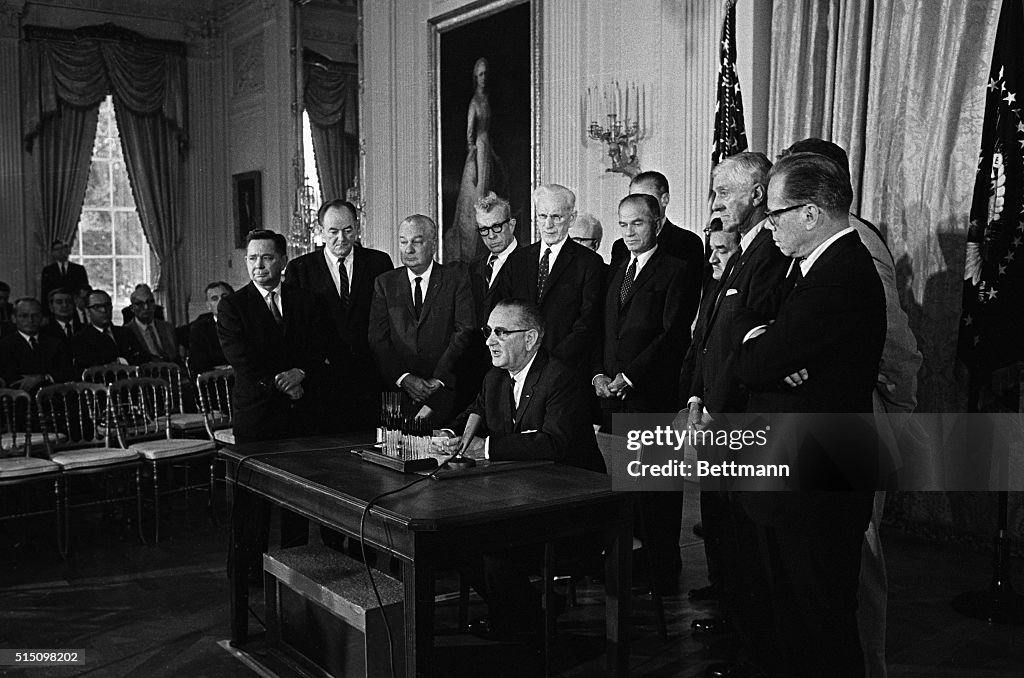 Lyndon Johnson Signing Law in Front of Senators