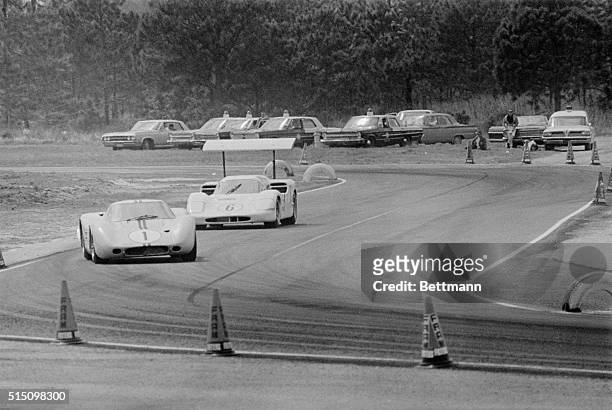 Ford GT Prototype driven by Marion Andretti and an airbrake-equipped Chaparral with Jim Hall behind the wheel, are shown as they battle for the lead...