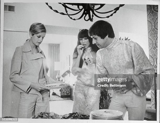 During her West Coast visit, Twiggy is the guest here of the celebrated team of Sonny and Cher. At a buffet breakfast, Sonny helps Twiggy to chow,...