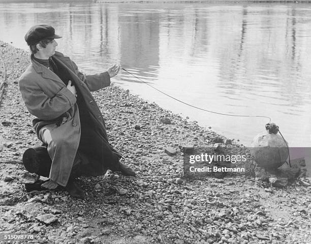 Beatle Ringo Starr uses a long cable release to take his own picture during a break in the shooting of A Hard Day's Night in London. He wears a cap...