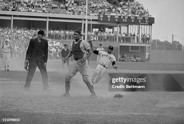 Willie Mays, of the National League All Star Team begins his slide into home plate in the ninth inning of the 35th All Star Classic here on July 7th....