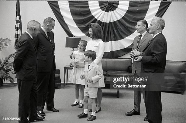 President Lyndon Johnson chats with Mrs. John F. Kennedy and her children, Caroline and John, Jr., prior to the christening of the aircraft carrier...