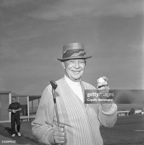 Former President Dwight D. Eisenhower flashes his famous smile as he holds the ball which he hit for a hole-in-one on the 104-yard par-3, 13th hole...