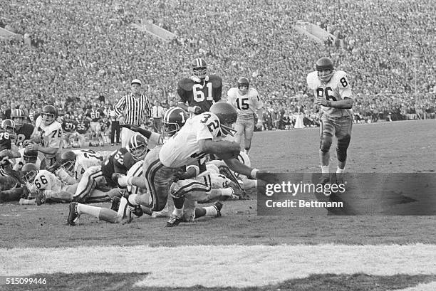 S invaluable O.J. Simpson eludes a host of Indiana tacklers and here leaps for the goal line to score USC's 2nd touchdown in the Rose Bowl game....