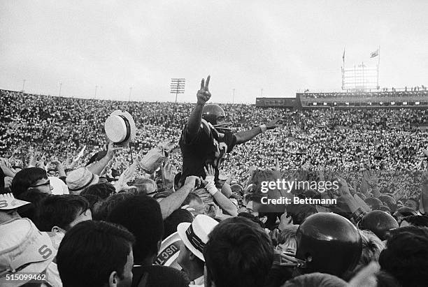 Simpson, USC's running back gives the victory sign as he is carried off the field by hundreds of cheering fans. Simpson scored two touchdowns. USC...