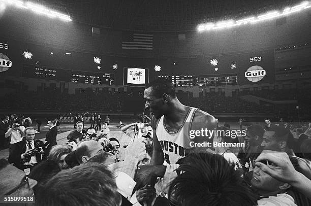 Houston's Elvin Hayes is carried from the court by jubilant fans after Houston scored a 71-79 upset over the UCLA Bruins. Amidst a fireworks display...