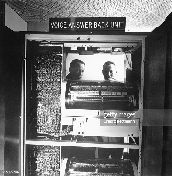 New York, NY - ORIGINAL CAPTION READS: Automation engineers inspect the open back of the special Voice Assembler "answer back" unit in the computer...