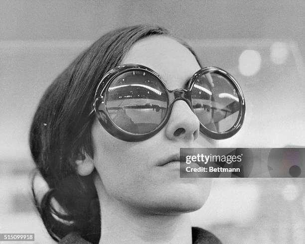 Dark glasses reflect the ice stadium of Grenoble and the girl wearing the sunglasses is none other than world figure skating champion Peggy Fleming....