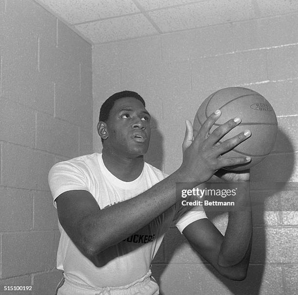 Willis Reed, New York Knicks basketball player, is shown in a posed action shot, holding a basketball.