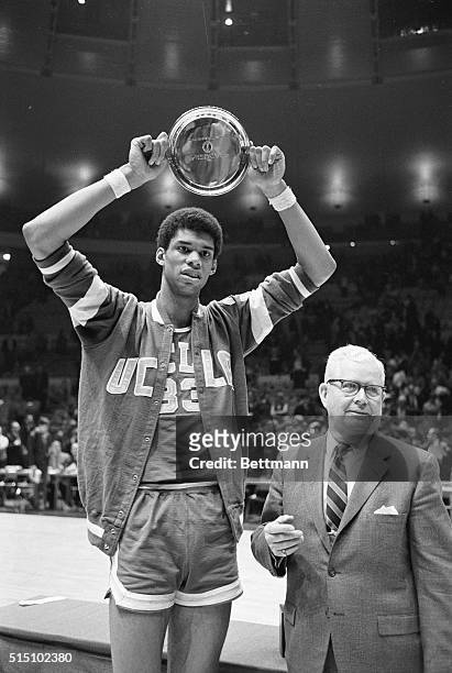S 7-foot 2-inch junior center Lew Alcindor, prior to his 1971 name change to Kareem Abdul-Jabbar, holds up the NCAA MVP Award following a game at St....