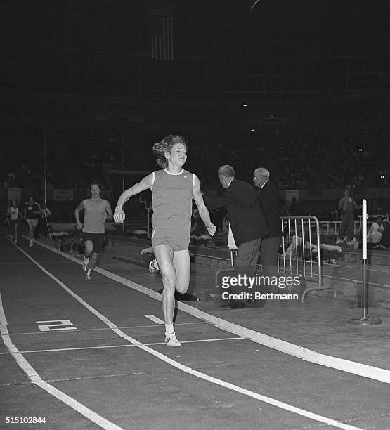 Doris Brown of the Falcon Track Club, in Seattle, Washington, shows strain on her face as she crosses the finish line to win the women's mile run of...