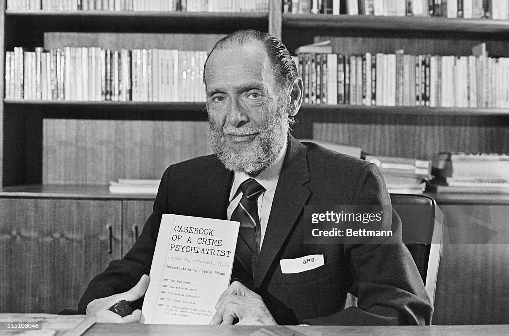 Dr James A Brussel Holding Copy of His Book