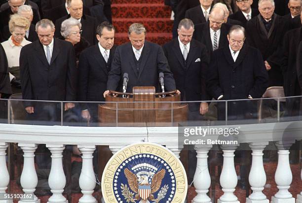 Reverend Billy Graham reciting prayer during inauguration ceremonies, January 20th. From left are: President Lyndon Johnson; President-elect Richard...