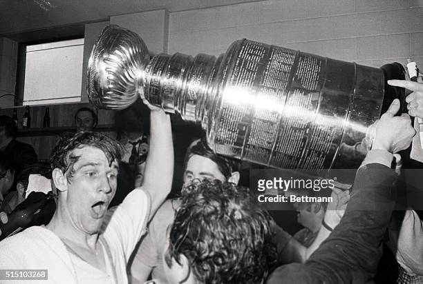 Bobby Orr helps raise the Stanley Cup in the locker room following the Bruins' Game 4 finals victory over the St. Louis Blues. Orr scored the...