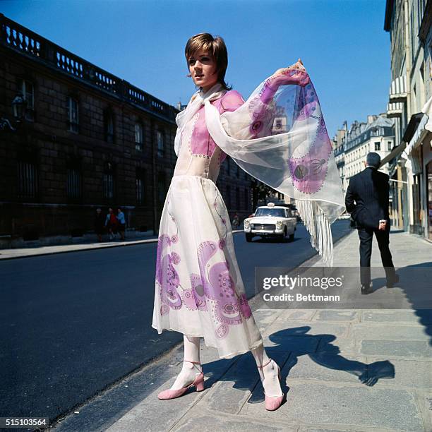 Midi-length Paris fashion by Louis Feraud includes a cold-weather dress in black fur-fabric, split high in front, with a yellow "life-jacket" bodice,...