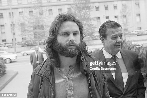 Jim Morrison , lead singer of the rock group "The Doors" is accompanied by his attorney Max Fink as he arrives at the Los Angeles Federal Building to...