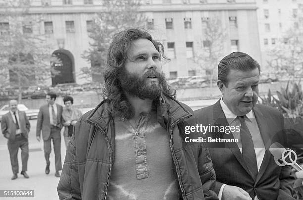 Jim Morrison , lead singer of the rock group "The Doors" is accompanied by his attorney Max Fink as he arrives at the Los Angeles Federal Building to...