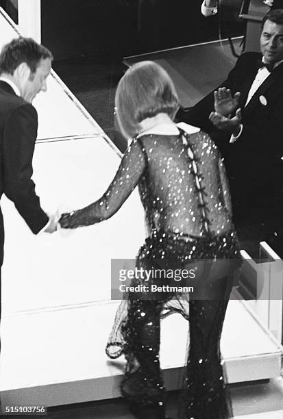 Los Angeles: Barbra Streisand stumbles and tears her "see through" gown as she goes up the steps to receive her share of the Best Actress Award at...